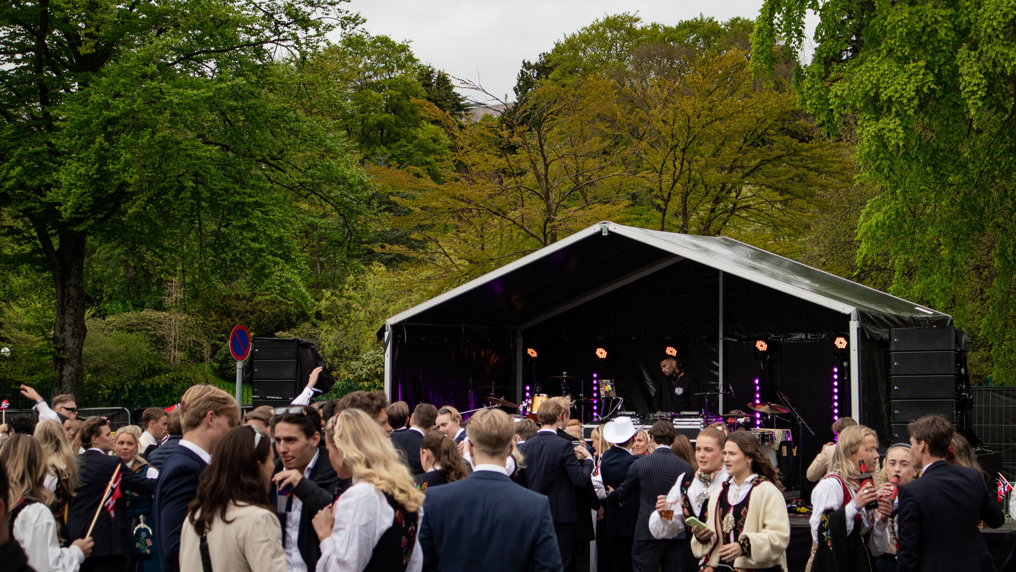 Ja, vi Elsker Bergen arrangementet på Marinehallen 17. mai 2023: Festivalområde med bord og benkesett til leie, partytelt, bar, popcornmaskin, slushmaskin, scenerigg, og partylys.